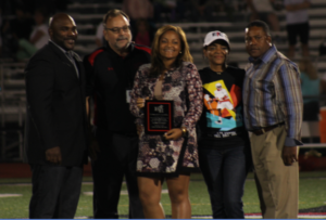 Principal Dennis Williams and Athletic Director Lou James stand with Erin Coombs, Tina Coombs and Eric Coombs 
