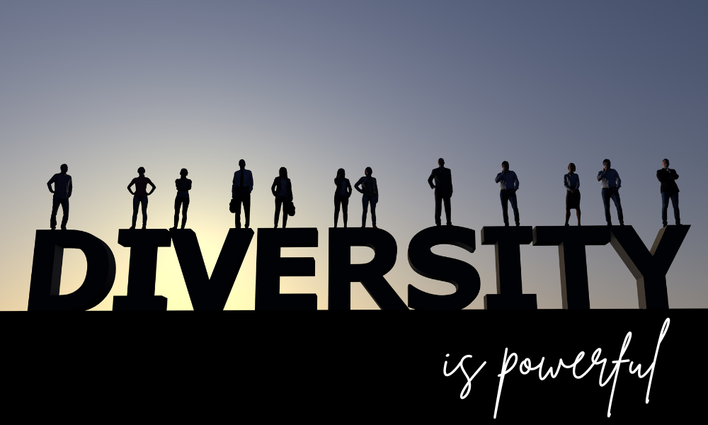 Individuals stand on the letters of "DIVERSITY" against a dusky sky