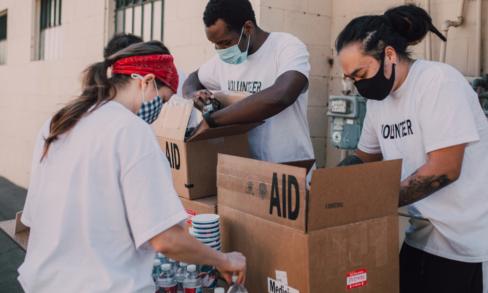an image of 3 people packing and wearing volunteer shirt