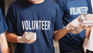 Volunteers in blue shirts handling canned goods