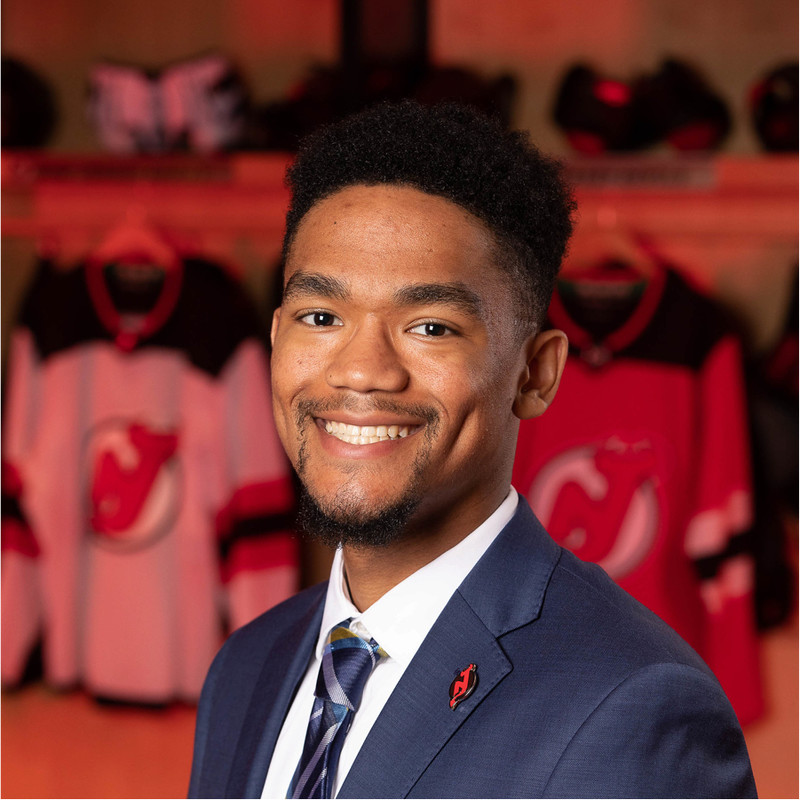 A smiling man dressed in a professional suit and tie.