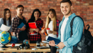 Smiling student with classmates in background, holding books