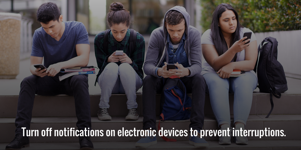 Four students sitting, focused on their phones instead of interacting

