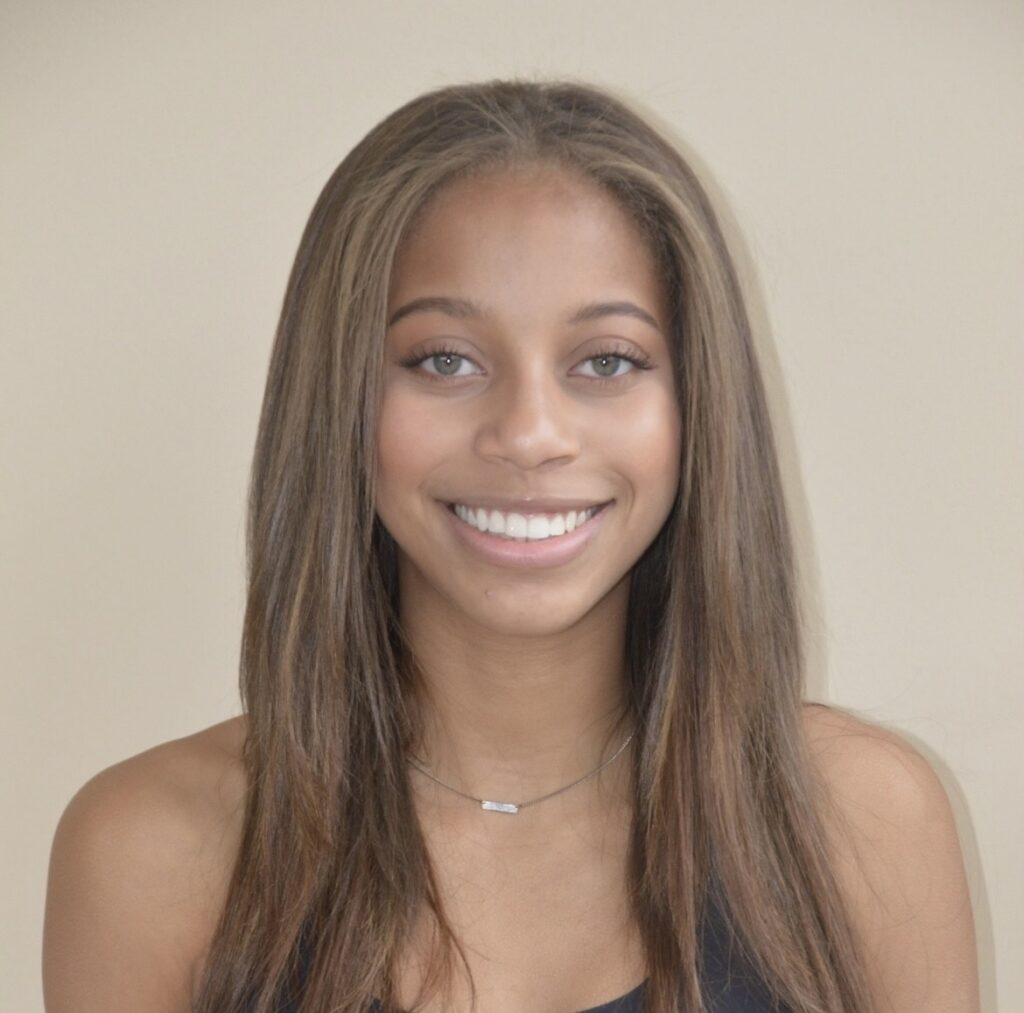 Smiling young woman with long brown hair and bright eyes